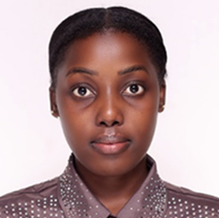 Ashaba Moureen Agroforestry specialist with a calm direct gaze, dark skin, and polka-dotted brown shirt against a light background