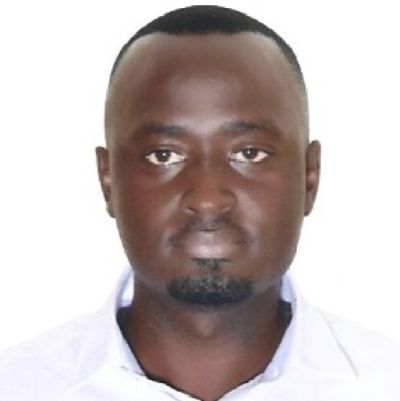 Atamba Joseph Brent Portrait of Atamba Joseph Brent, a man with closely cropped hair and a trimmed goatee wearing a white collared shirt
